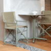 Boss sling folding chairs with tan fabric and green polypropylene frames paired with a square café table