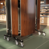 close up of folded cafeteria tables with walnut laminate panels and heavy duty casters for mobility