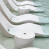 White Forma luxury in-pool chaise lounges paired with matching in-pool side tables on a shallow tanning ledge