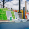 White Forma pool edge chairs positioned along the edge of a commercial water park pool