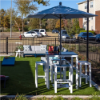 Skyline aluminum backless commercial outdoor bar stools with MGP seats arranged around a bar-height table beneath a patio umbrella
