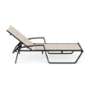 Side view of Skyline padded sling chaise lounge with Cane Oyster fabric, Starlight Black aluminum frame, armrests, and adjustable backrest