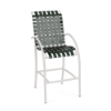 Front perspective view of a high-top commercial patio bar stool with a white aluminum frame, integrated footrest, and dark Holly Green woven vinyl straps.