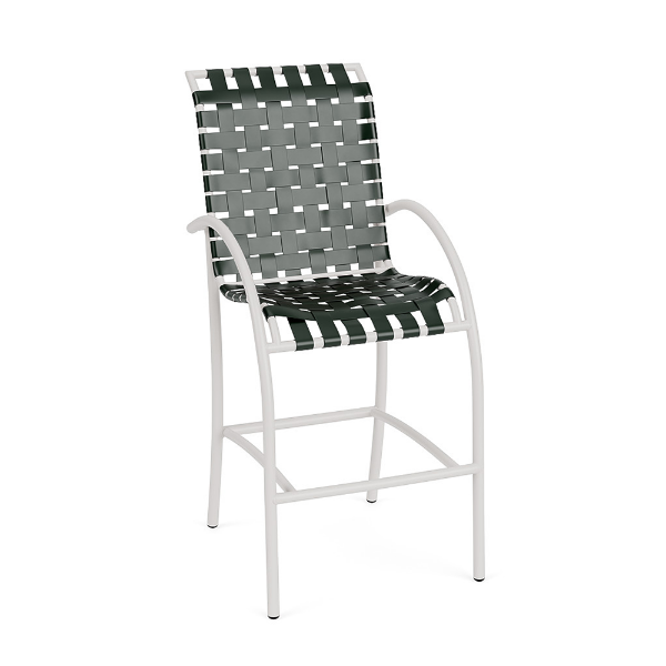 Front perspective view of a high-top commercial patio bar stool with a white aluminum frame, integrated footrest, and dark Holly Green woven vinyl straps.