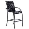 Three-quarter front view of an elevated commercial outdoor bar chair featuring curved armrests, a footrest rung, a black metal frame, and black vinyl cross-weave strap seating.
