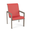 Three-quarter perspective view of a sleek commercial poolside dining chair featuring a beige Satin Amber aluminum frame paired with a coral pink Straw Mat textured sling.