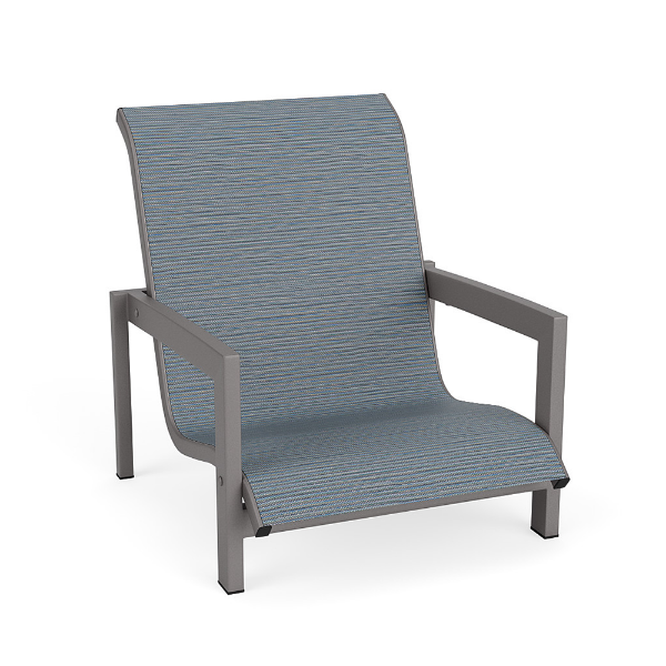 Three-quarter front view of a low-to-the-ground commercial outdoor sand lounge chair with a Titanium Gray metallic frame and a textured slate blue Kozo Jewel sling.