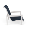 Side profile view of a low-profile commercial outdoor sling sand chair featuring a powder-coated Sky White aluminum frame, wide armrests, and a dark navy blue Dupione Sapphire fabric sling seat.