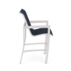 Side profile view of an elevated commercial outdoor patio bar stool featuring a powder-coated Sky White aluminum frame, footrest stretcher bars, and a navy blue Dupione Sapphire fabric sling seat.