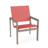 Three-quarter perspective view of a commercial outdoor dining chair with a beige Satin Amber powder-coated frame and a bright coral pink Straw Mat textured double sling.