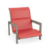 Front perspective view of a low-profile outdoor commercial sand chair with a beige Satin Amber aluminum frame and bright coral pink Straw Mat textured padded fabric.