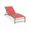 Three-quarter view of an outdoor commercial chaise lounge with a warm beige Satin Amber powder-coated frame and a coral red Straw Mat woven sling.