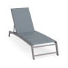 Front three-quarter perspective view of an outdoor commercial lounge chair built with a Titanium Gray frame and a slate blue Kozo Jewel padded sling surface.