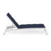 Side view profile of an adjustable commercial chaise lounge featuring angled Sky White aluminum legs and a plush navy blue Dupione Sapphire padded sling seat.