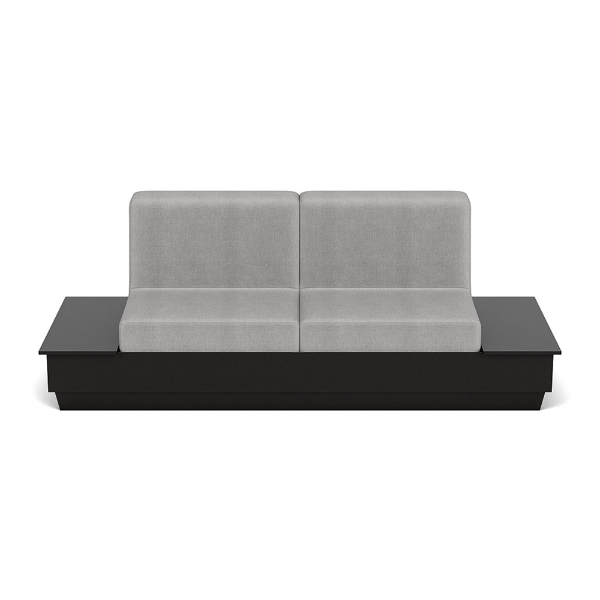 A straight-on front studio product shot of a commercial outdoor sofa featuring an extended Black Granite Marine Grade Polymer (MGP) platform base with built-in side tables on both ends and plush light gray outdoor cushions.