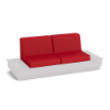 A front three-quarter view studio product shot of a commercial outdoor sofa featuring a wide White Marine Grade Polymer (MGP) platform base with integrated side table surfaces and bold Logo Red upholstered cushions.