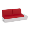 A front three-quarter view studio product shot of a commercial outdoor sofa featuring a White Marine Grade Polymer (MGP) platform base with a built-in side table surface on the left side and bold Logo Red upholstered cushions.