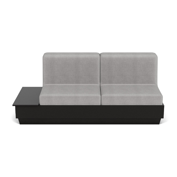 A straight-on front studio product shot of a commercial outdoor sofa featuring a Black Granite Marine Grade Polymer (MGP) platform base with an integrated side table surface on the left side and thick light gray outdoor fabric cushions.