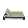 Side elevation view of a two-person commercial outdoor chaise lounge featuring a dark wicker frame with dual reclined backrests and green-and-white patterned cushions.