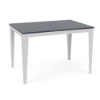 Three-quarter perspective view of a rectangular MGP outdoor bar table featuring a navy blue slatted tabletop with an umbrella hole set on a white frame with tapered legs.