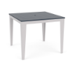Three-quarter perspective view of a 48-inch square MGP outdoor bar-height table featuring a navy blue slatted top with a centered umbrella hole, set on a white frame with tapered legs.
