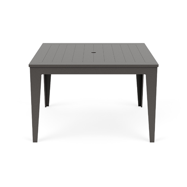 Straight-on front view of a 48-inch square MGP outdoor dining-height table featuring a uniform dark grey finish on both the slatted top (with a centered umbrella hole) and tapered legs.