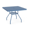 Eye-level perspective view of a 36-inch square Sundance commercial aluminum outdoor dining table in a Steel Blue finish, featuring flared legs with umbrella cross-bracing and a square tabletop with a scattered bubble perforation design and central umbrella hole.
