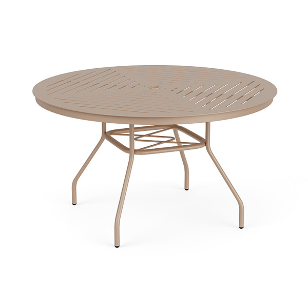 Three-quarter perspective view of a 48-inch round Sundance commercial aluminum outdoor dining table in Textured Antique Beige, featuring curved legs, an umbrella support brace, and a slotted slat pattern tabletop with a central umbrella opening.