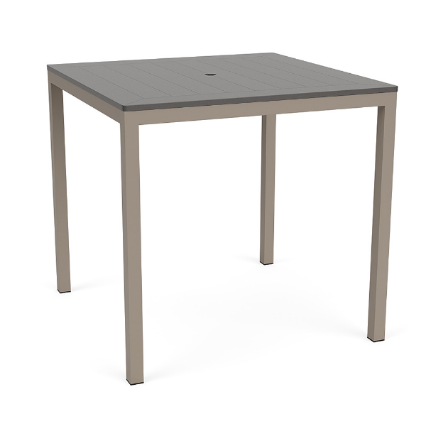 A 42-inch square bar-height patio table featuring a neutral grey slatted MGP tabletop with an umbrella hole, supported by a Satin Amber beige aluminum frame.