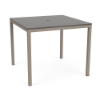 A 48-inch square bar-height patio table featuring a neutral grey slatted MGP tabletop with an umbrella hole, supported by a Satin Amber beige aluminum base.