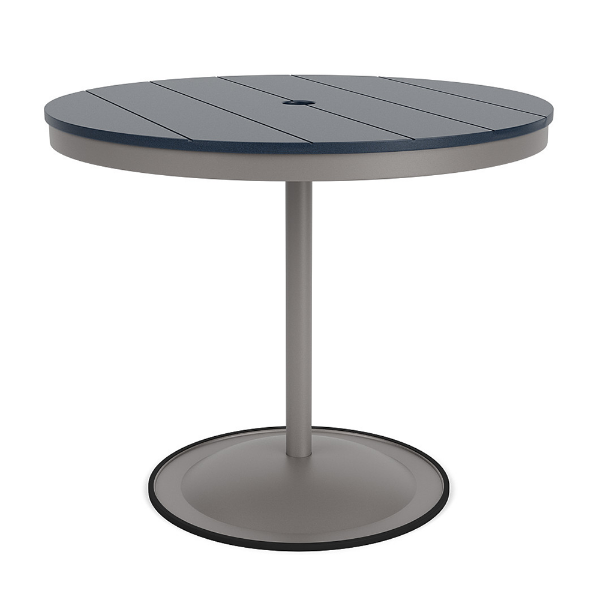 A 36-inch round commercial patio dining table built with a Platinum metallic powder-coated aluminum pedestal base and a circular weighted stand, featuring a navy blue Marine Grade Polymer (MGP) slatted surface with an umbrella hole.