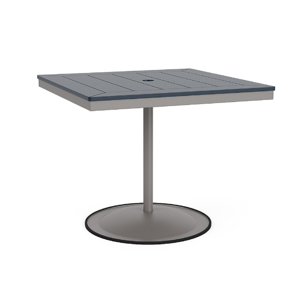 A 36-inch square commercial patio dining table built with a Platinum metallic powder-coated aluminum pedestal base and a circular weighted stand, featuring a navy blue Marine Grade Polymer (MGP) slatted surface with an umbrella hole.