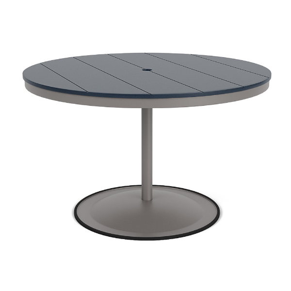A 48-inch round commercial patio dining table built with a Platinum metallic powder-coated aluminum pedestal base and a circular weighted stand, featuring a navy blue Marine Grade Polymer (MGP) slatted surface with an umbrella hole.